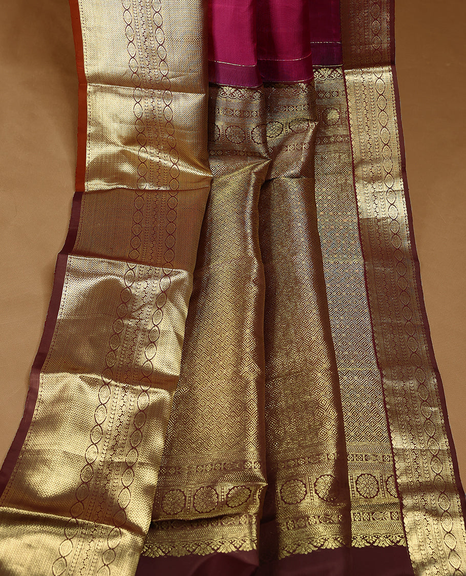 Mulberry coloured pure traditional Kancheepuram silk saree featuring antique zari floral motifs, complemented by a traditional self coloured border and a matching blouse.