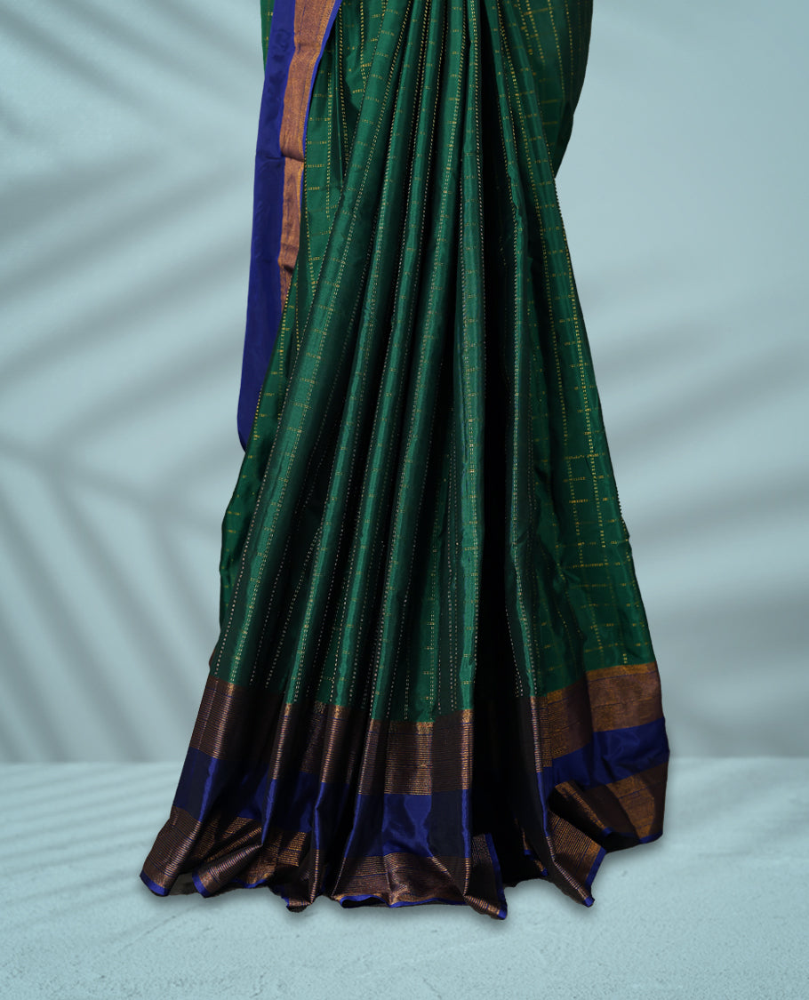Green Colour semi silk saree features golden thread checks all over, complemented by a rich contrast blue and Golden zari border, and comes with a matching blouse.