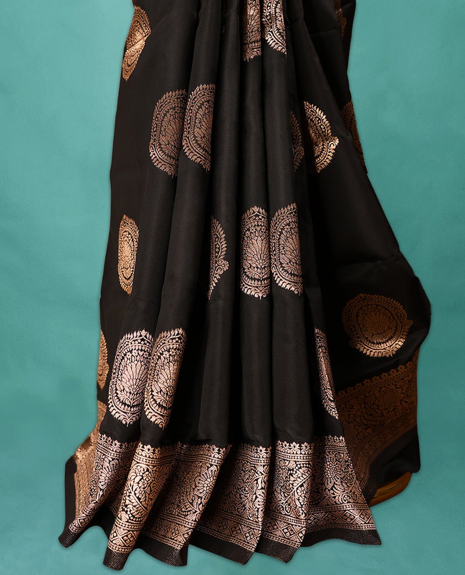 Black coloured semi silk saree featuring a Golden Zari Butta design on the body, paired with a Self coloured border and matching blouse.