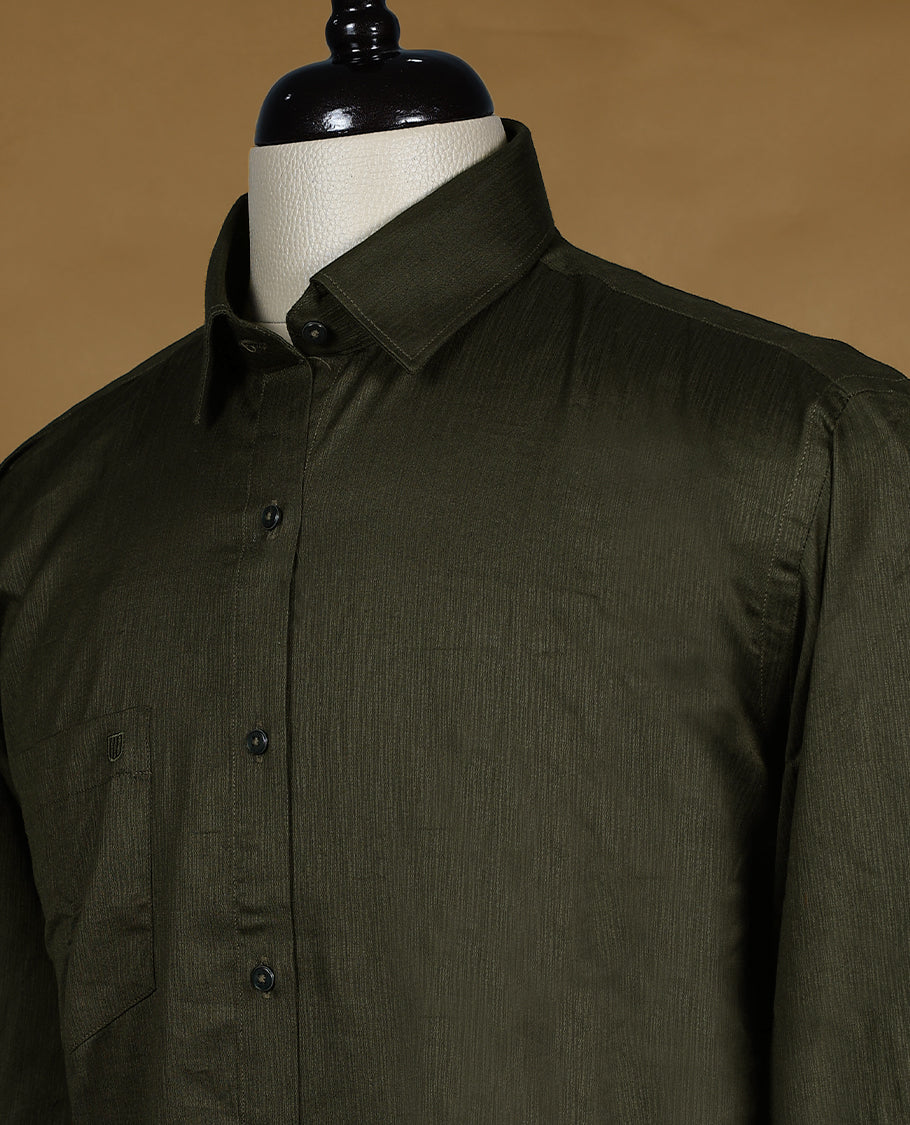 Deep olive green colour OTTO men's shirt in a relaxed formal fit, featuring a subtle self design pattern, classic collar, full sleeves, and a front chest pocket ideal for work or smart casual wear.