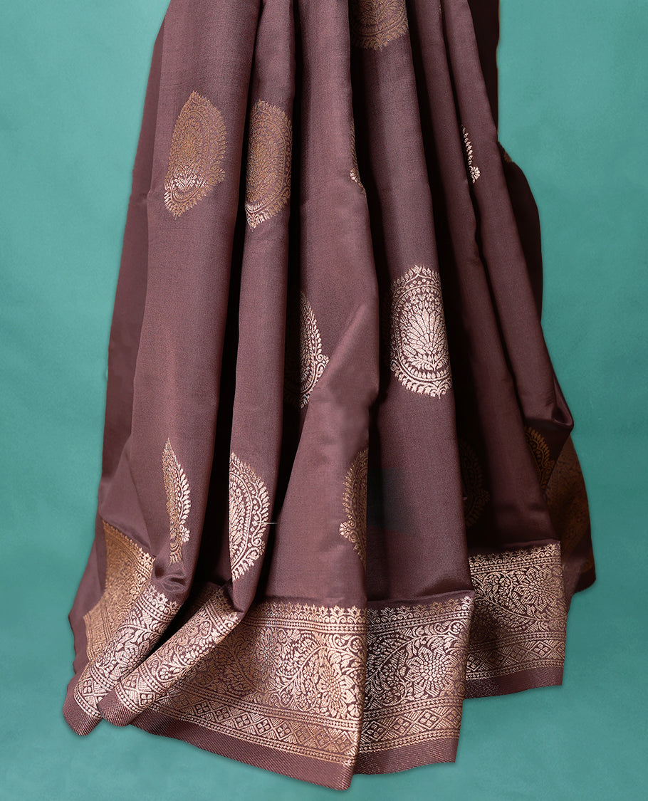 American Brown coloured semi silk saree featuring a Golden Zari Butta design on the body, paired with a Self coloured border and matching blouse.