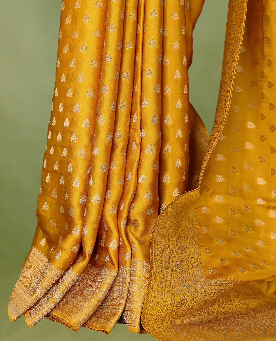 Mustard Gold semi-Banaras satin crepe saree featuring traditional closely woven buttas on the body, complemented by an antique-style border and a matching self-coloured blouse.
