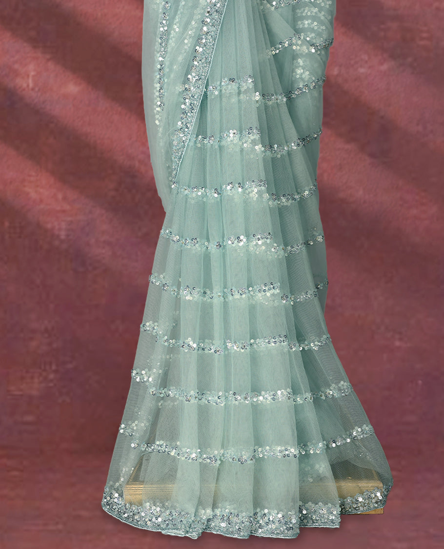 Pastel mint green colour net designer saree adorned with shimmering sequin stripes all over and a sequin embellished border with beaded tassel detailing on the pallu, paired with a matching worked blouse for a chic festive look