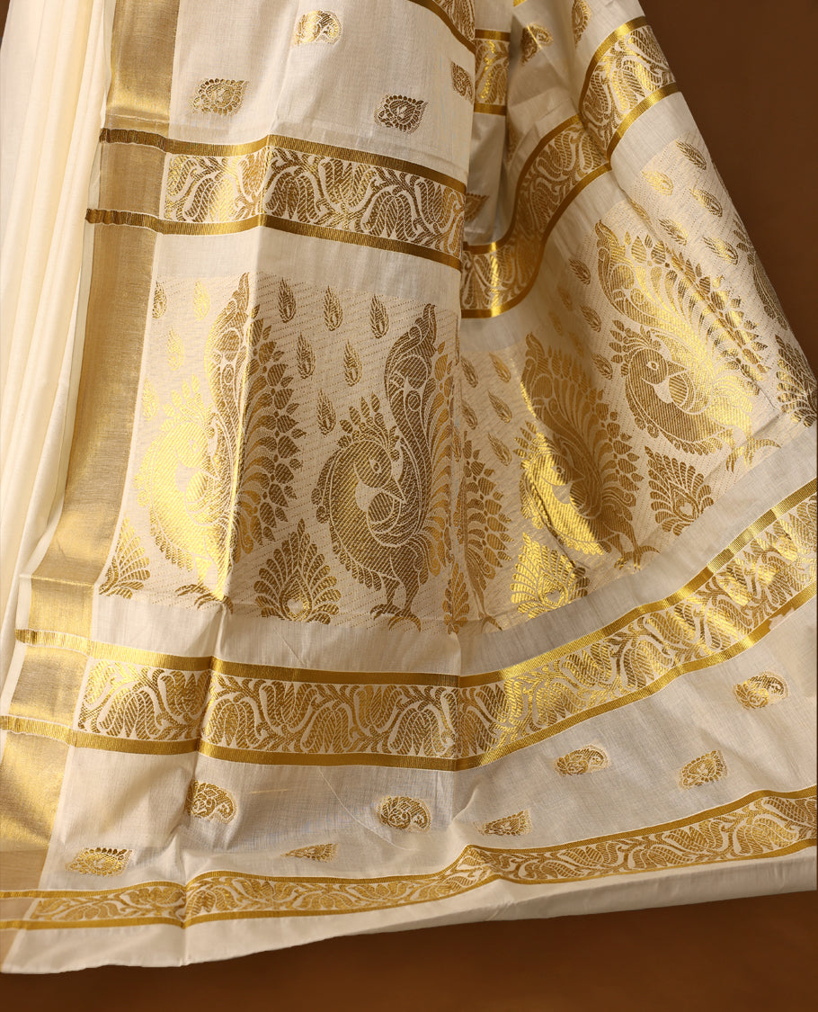 Elegant off white colour cotton Kerala saree featuring Gold zari motifs on body, traditional golden zari kasavu border & Rich Pallu offering a classic and graceful look, paired with a matching blouse.