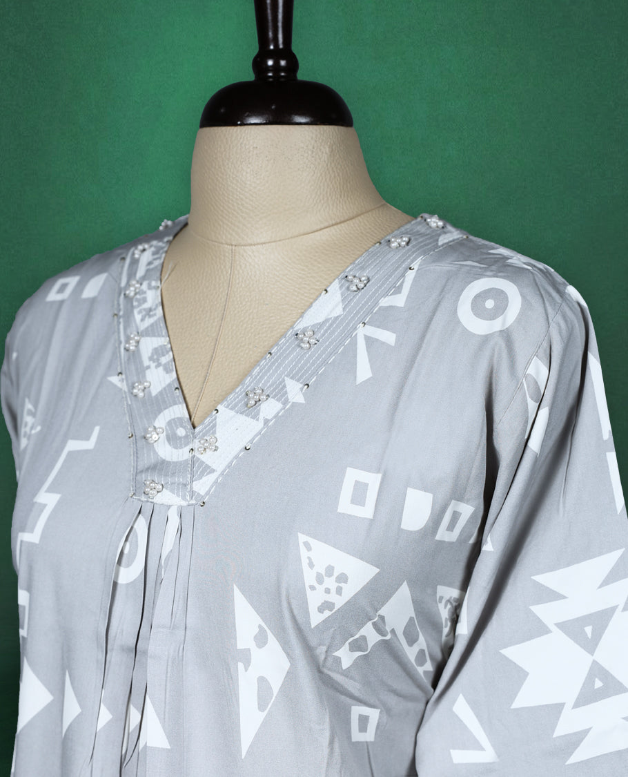 Light grey colour kurti featuring white tribalinspired geometric prints, styled with a V neckline adorned with subtle thread embroidery and 3/4th sleeves ideal for a contemporary ethnic look.