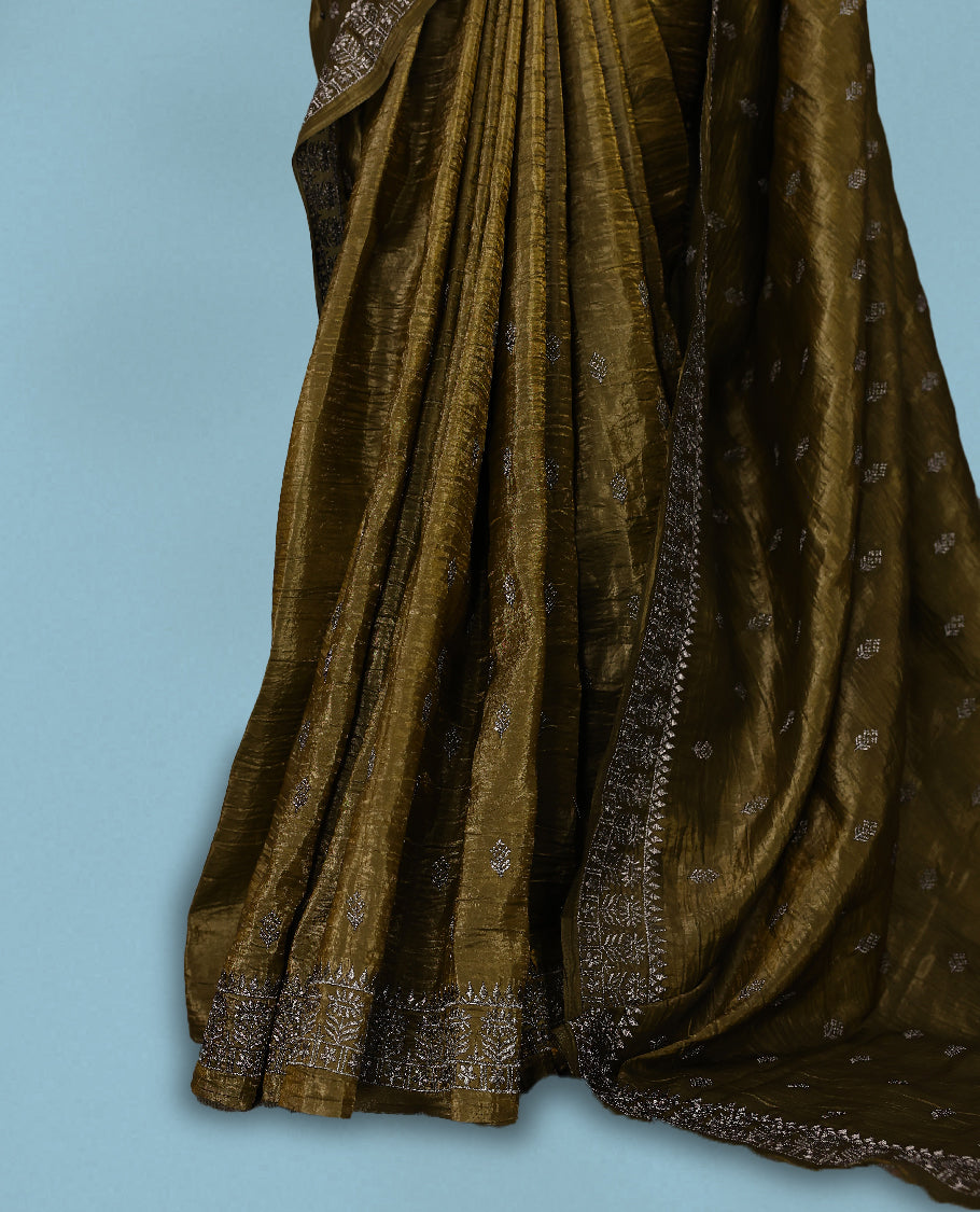 Olive Colour crush soft silk saree, textured body with a natural crinkled finish, adorned with intricate Silver colored floral Motifs and complemented by a delicate Silver Zari embroidery border, paired with a matching blouse
