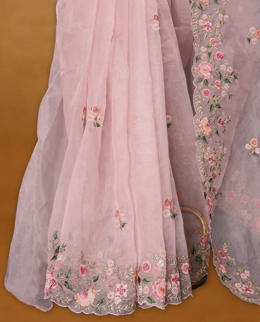 Pastel Pink Organza Tissue Silk Saree is beautifully adorned with intricate pink floral embroidery Border and a matching blouse.