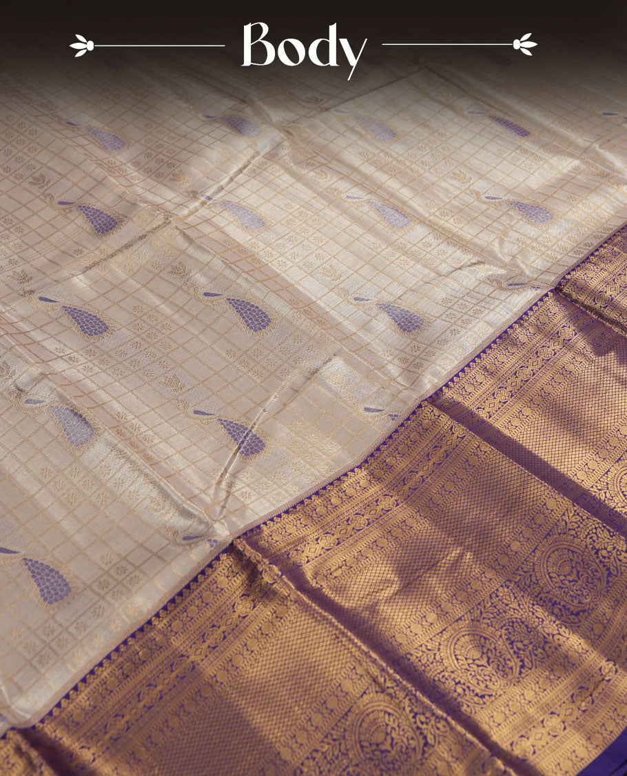 Cream Silk Saree with Purple & Gold Zari Checkered Grid Body, Textured Oval Buttas, Elegant Decorative Pallu Border, Grand Pallu with Ornate Peacock and Floral Motifs in Purple and Gold Tones, and Matching Purple Blouse.