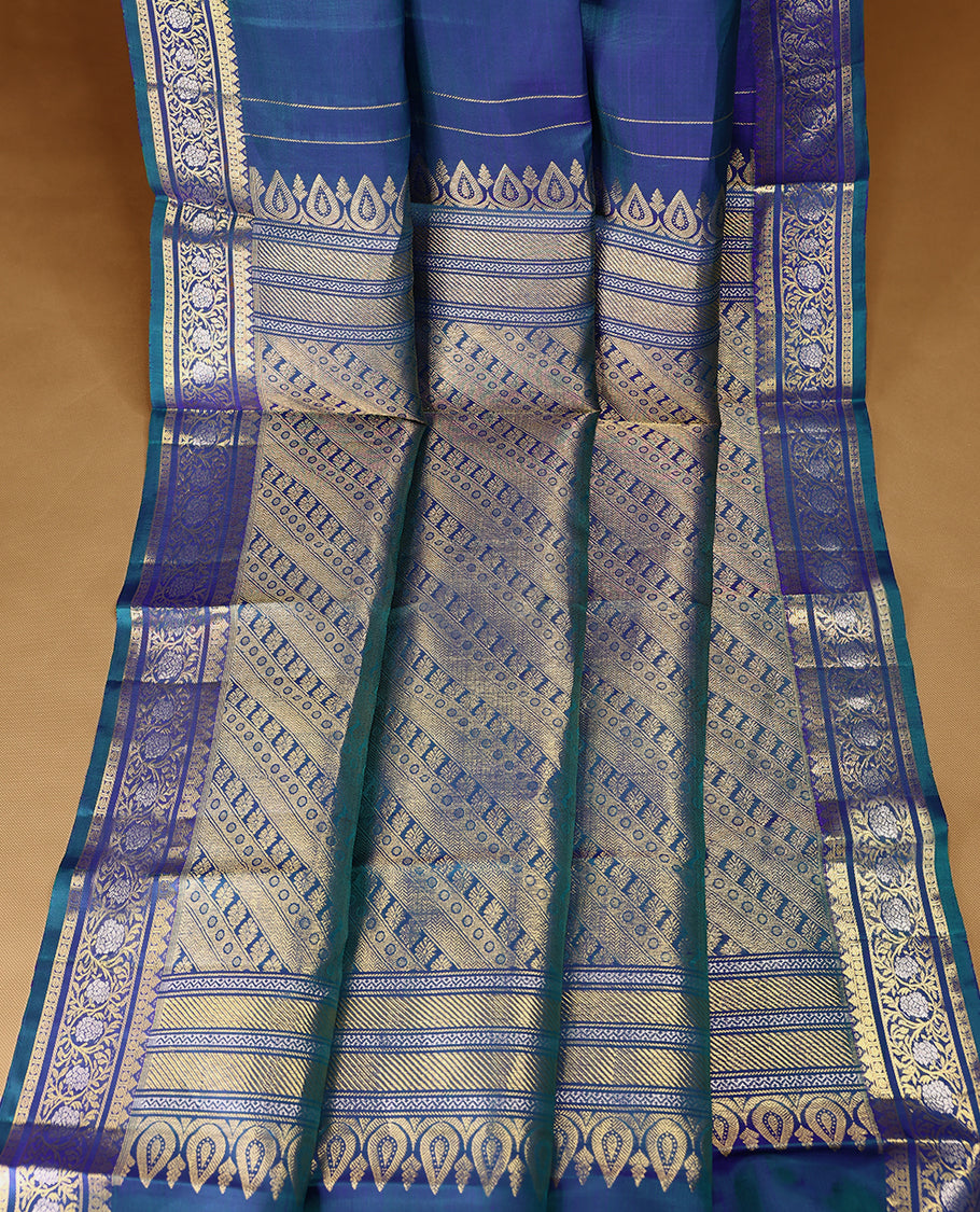 Double-shade peacock-coloured traditional Kancheepuram silk saree adorned with antique floral motifs on the body, featuring a traditional border with floral kodi designs, and paired with a matching blouse
