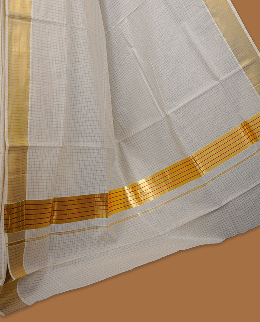 Off-white colour cotton Kerala saree featuring a subtle golden checkered body, highlighted with a classic gold kasavu border accented by fine red lines, and finished with a matching cotton blouse.