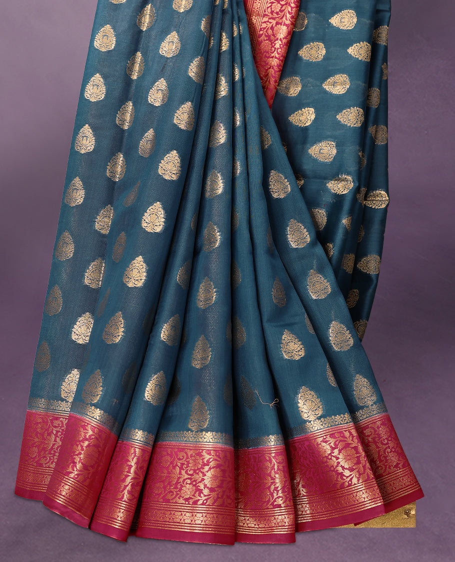 German Blue colour pure Banarasi Chanderi cotton fabric, featuring traditional antique zari buttas on the body, complemented by a traditional Rani Pink Colour border and a matching blouse.