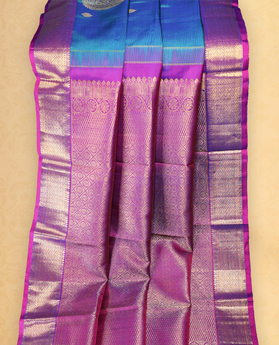 Peacock blue colour pure Kancheepuram saree with gold zari paisley mango motifs on the body traditional border with diamond pattern and purple piping grand pallu paired with matching blouse