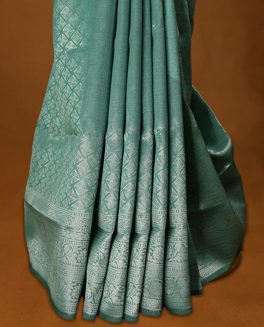 Pastel Aqua coloured semi silk saree featuring a Silver coloured Zari Diamond design on the body, paired with a Self coloured border and matching blouse.