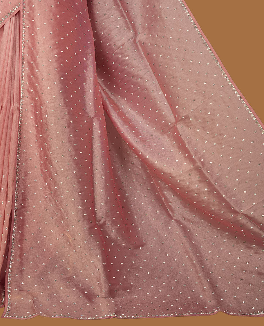 Dusty rose colour net shimmer fancy saree adorned with scattered white stone buttas, paired with a delicate stone worked border and matching blouse.