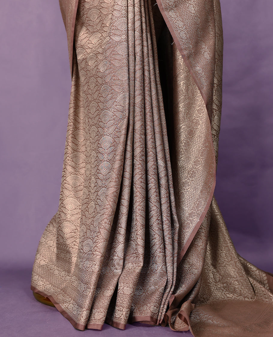 Pastel brown colour semi Banaras Katan saree featuring an antique silver zari jacquard body, complemented by a self colour traditional border with a floral kodi design, paired with a matching blouse