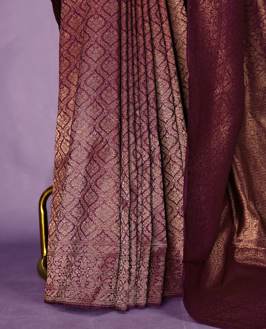 Grape colour semi Banaras Katan saree featuring an antique Gold zari jacquard body, complemented by a self colour traditional border with a floral kodi design, paired with a matching blouse