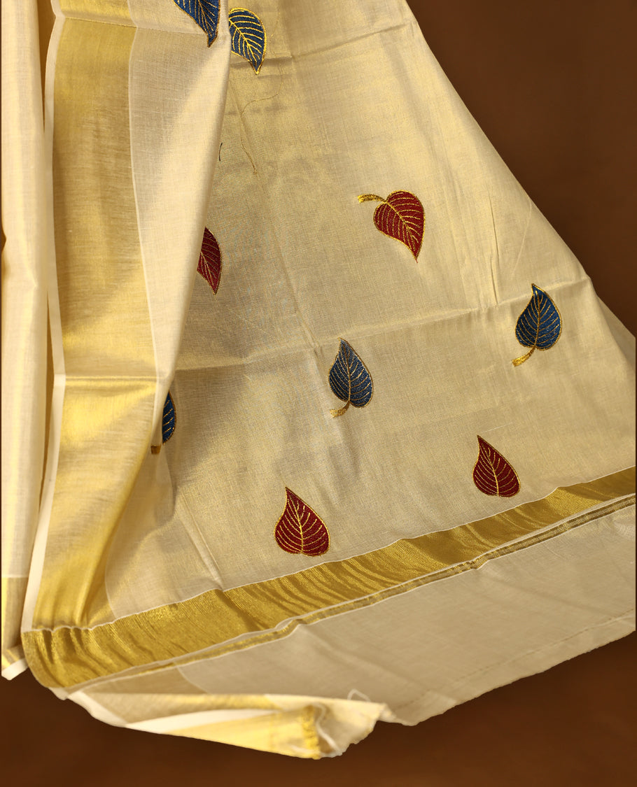 Light Gold colour Tissue Kerala saree featuring leaves Embroidery body and a beautifully woven Gold Kasavu border, paired with a matching blouse perfect for festive occasions.