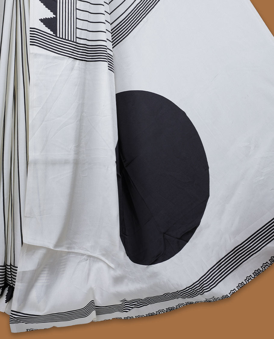 White colour semi modal saree highlighted with black triangle border accents and sleek striped detailing across the drape, featuring a bold oversized black circular motif on the pallu, paired with a matching printed blouse.