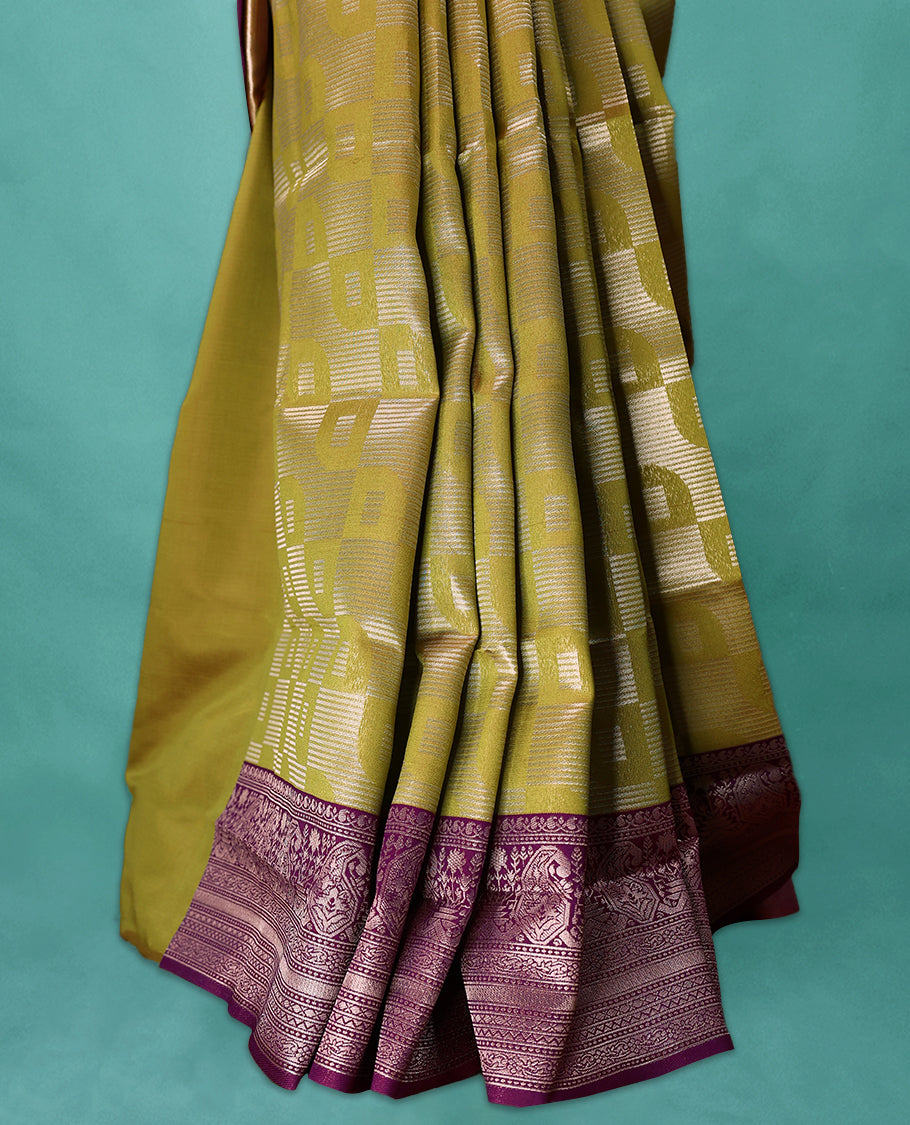 Mung Bean coloured semi silk saree featuring a Silver coloured Zari design on the body, paired with a Grape coloured border and matching blouse.