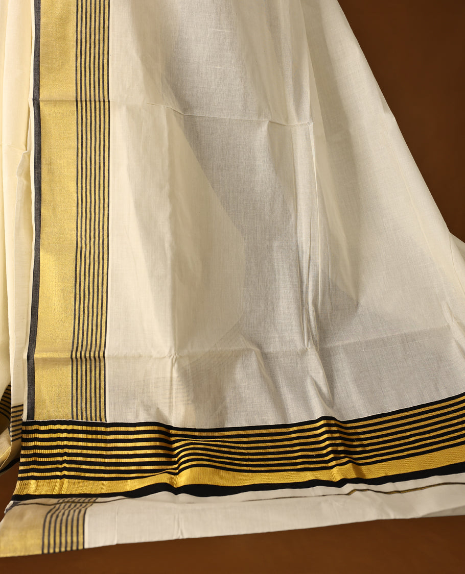 Classic pure cotton Kerala saree with a cream base, golden zari border, and elegant black striped detailing, A timeless choice for traditional events and festive occasions & Comes with a matching blouse piece.