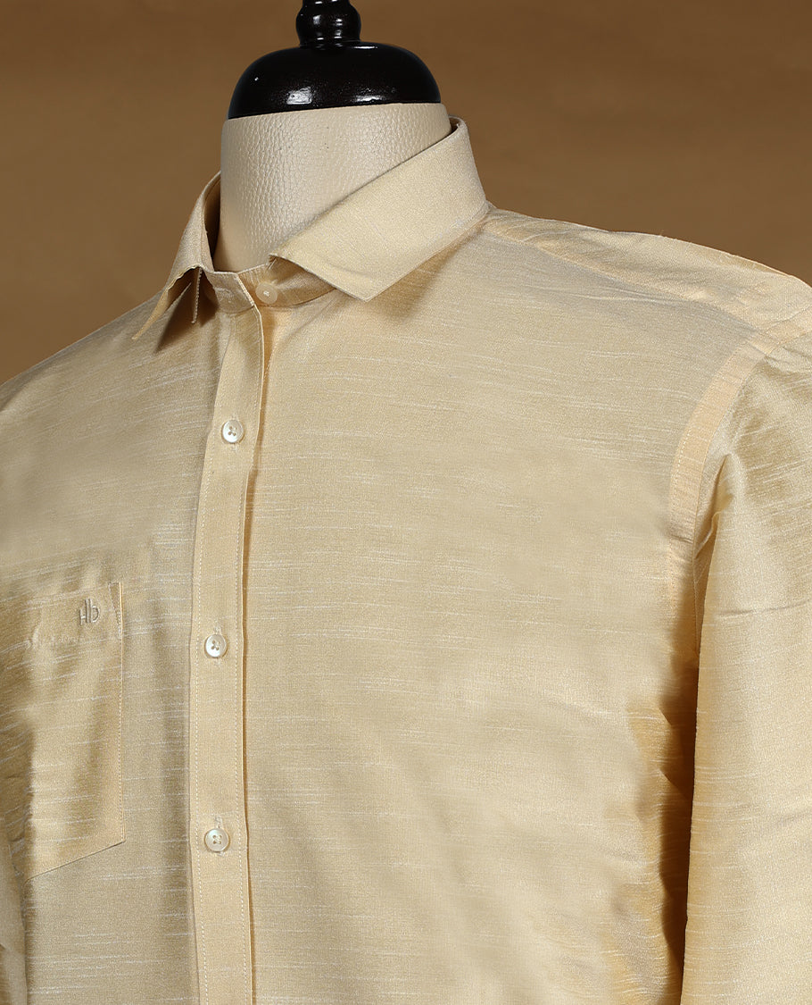 Golden beige DH men’s shirt featuring a glossy silk finish with self textured weave, full sleeves, classic collar, and chest pocket ideal for weddings and traditional functions