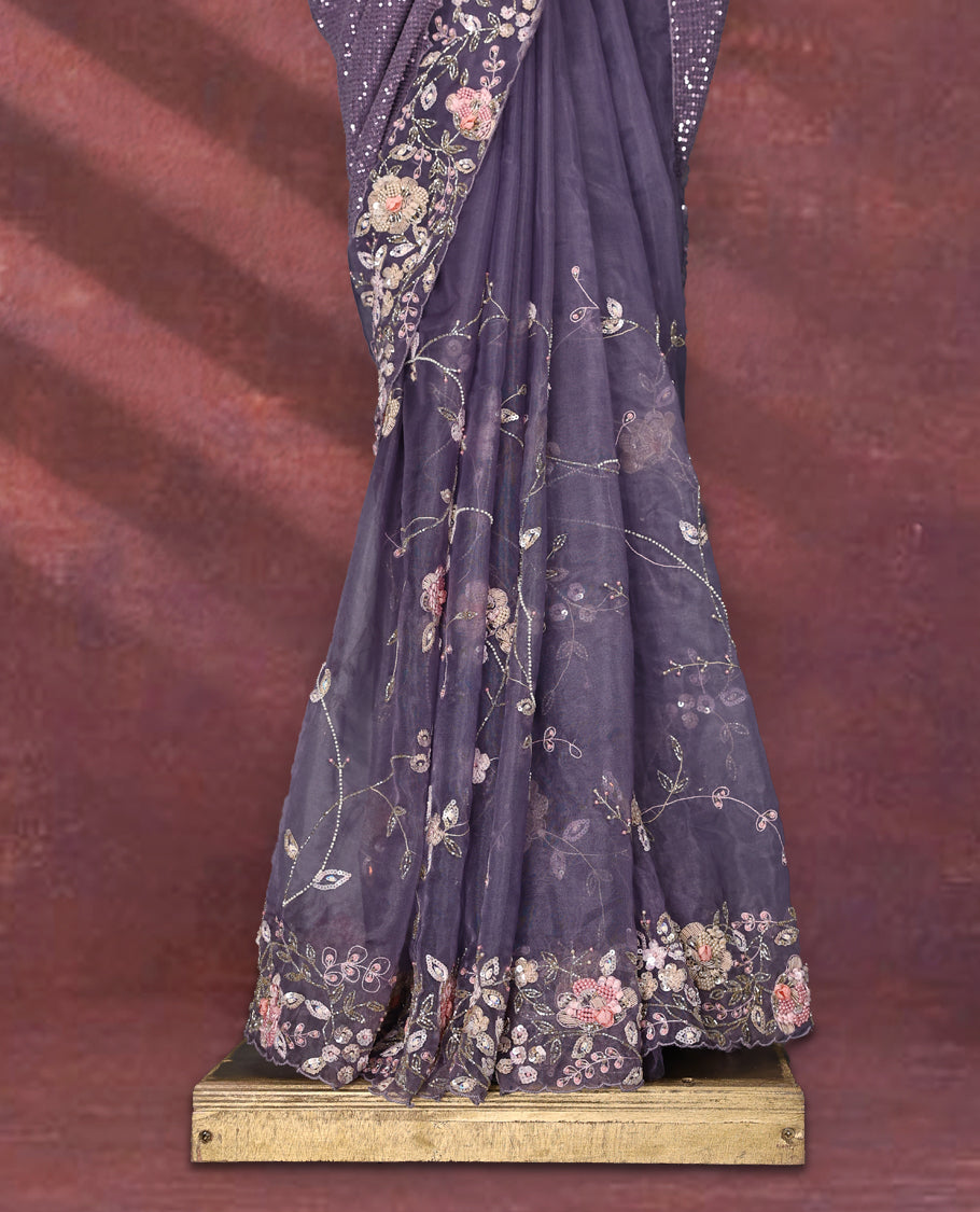 Pastel purple colour pure organza saree featuring all over sequin work, adorned with a matching floral kodi intricately worked border, complemented by a richly worked pallu and paired with a heavily embellished matching blouse.