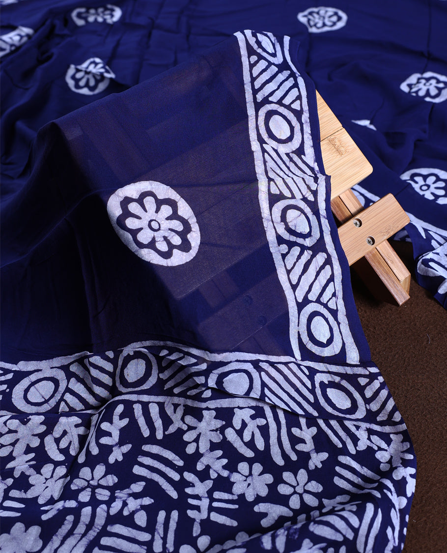 Navy blue colour churidhar material adorned with gold and copper toned floral patterns and bold block designs, paired with a plain matching bottom and stylish dupatta, perfect for festive evenings and traditional gatherings.