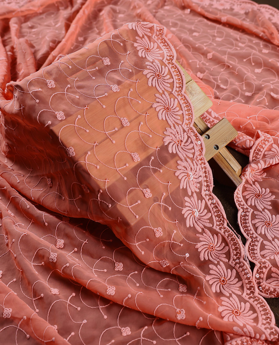Charming peach pink colour churidhar material highlighted with intricate floral embroidery and delicate sequin accents, paired with a plain matching bottom and embroidered dupatta, perfect for festive gatherings and elegant occasions.