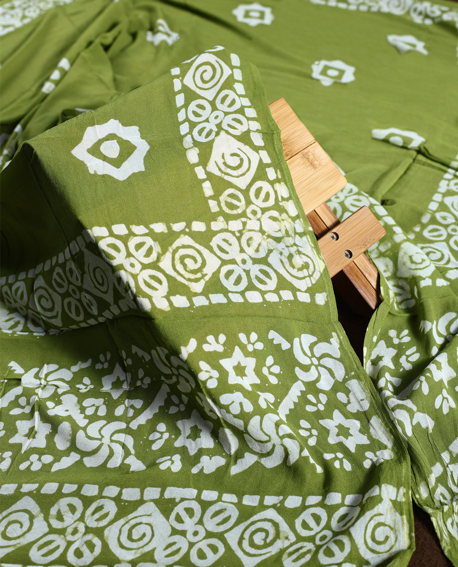 Light green colour churidhar material adorned with gold and copper toned floral patterns and bold block designs, paired with a plain matching bottom and stylish dupatta, perfect for festive evenings and traditional gatherings.