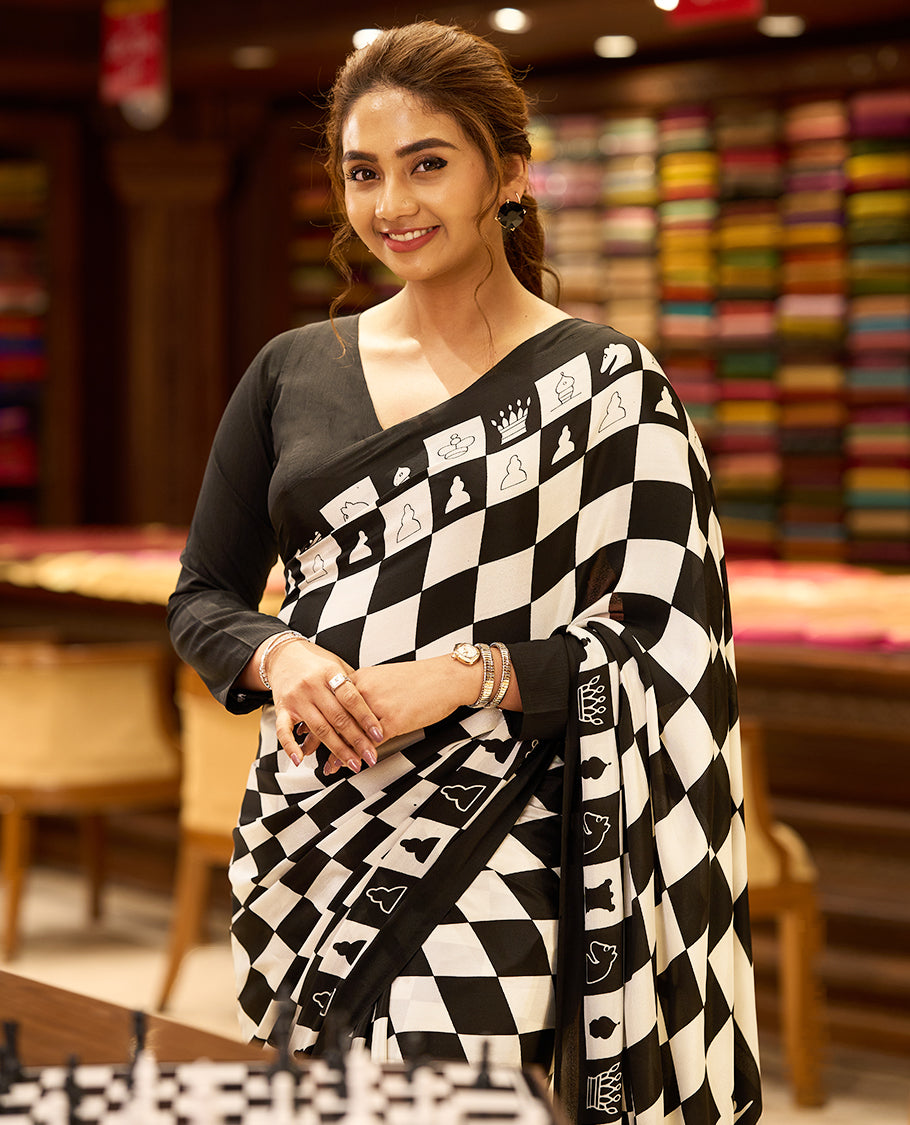 Striking black and white chessboard themed saree with bold checkered patterns and unique chess piece motifs across the body and pallu, paired with a solid black matching blouse for a bold, statement look