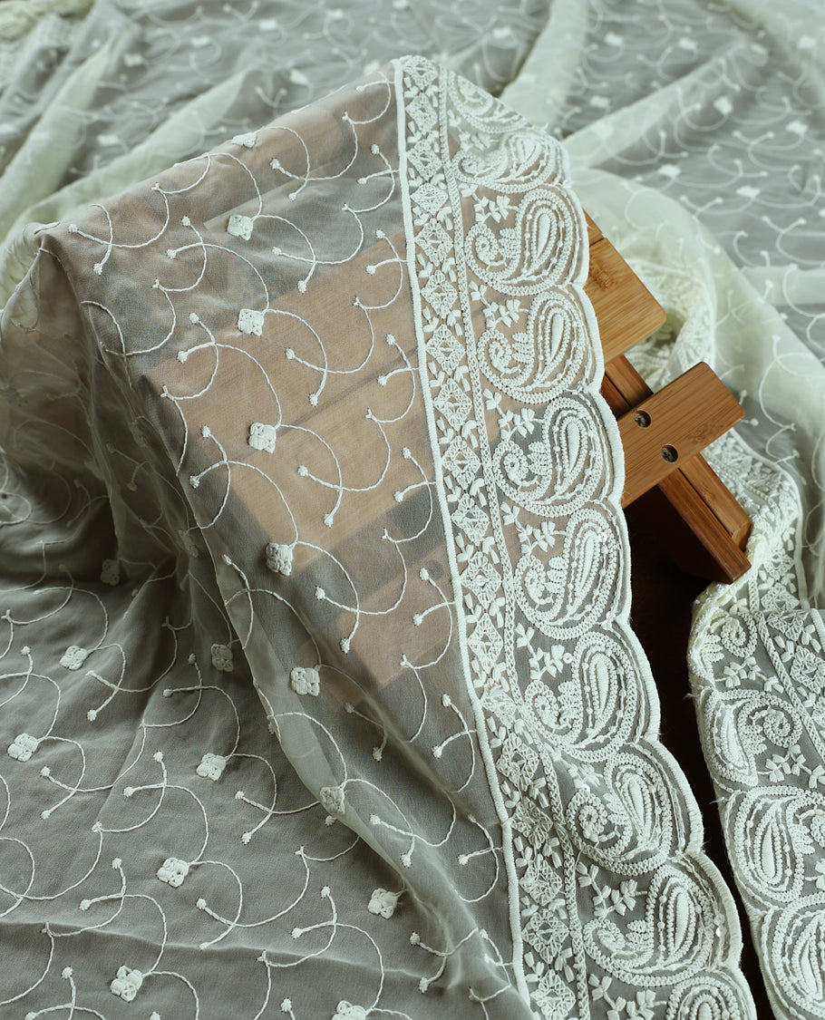 Cream colour churidhar material with heavy embroidered neck work, delicate floral motifs on the body, and multicolor panel detailing & Comes with matching plain bottom and embroidered net dupatta.