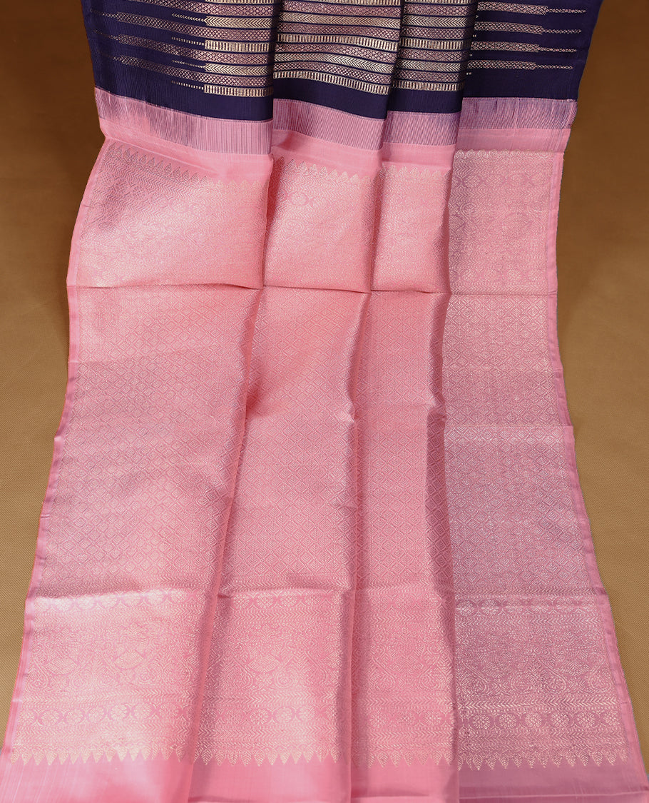 Ink purple colour Kancheepuram designer saree adorned with distinctive vertical zari lines featuring intricate arrowhead and herringbone motifs on the body, designed without a border, and paired with a matching blouse.