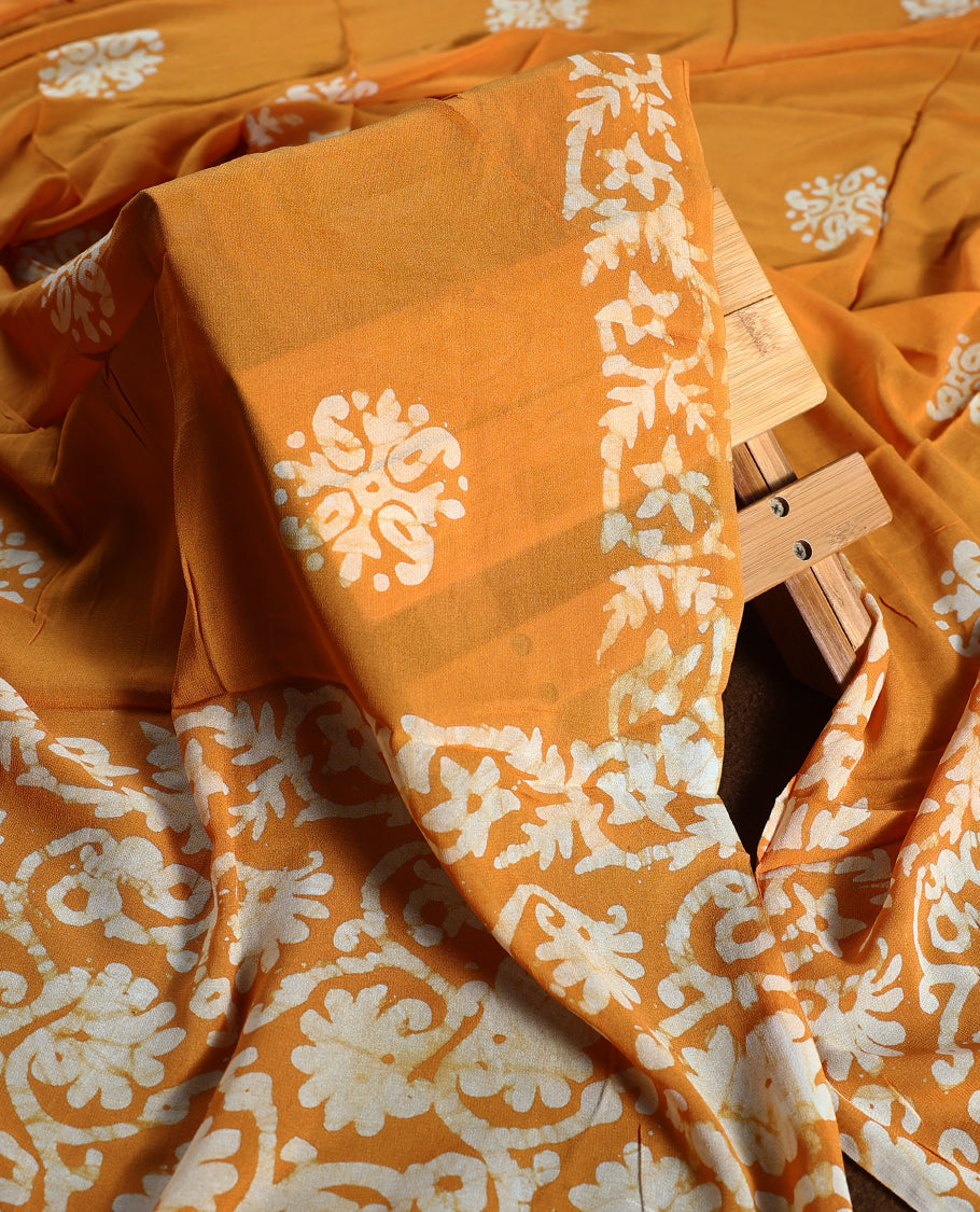 Deep yellow colour churidhar material featuring delicate floral patterns with gold highlights and bold block designs, paired with a plain matching bottom and a dupatta featuring bold white floral block prints.