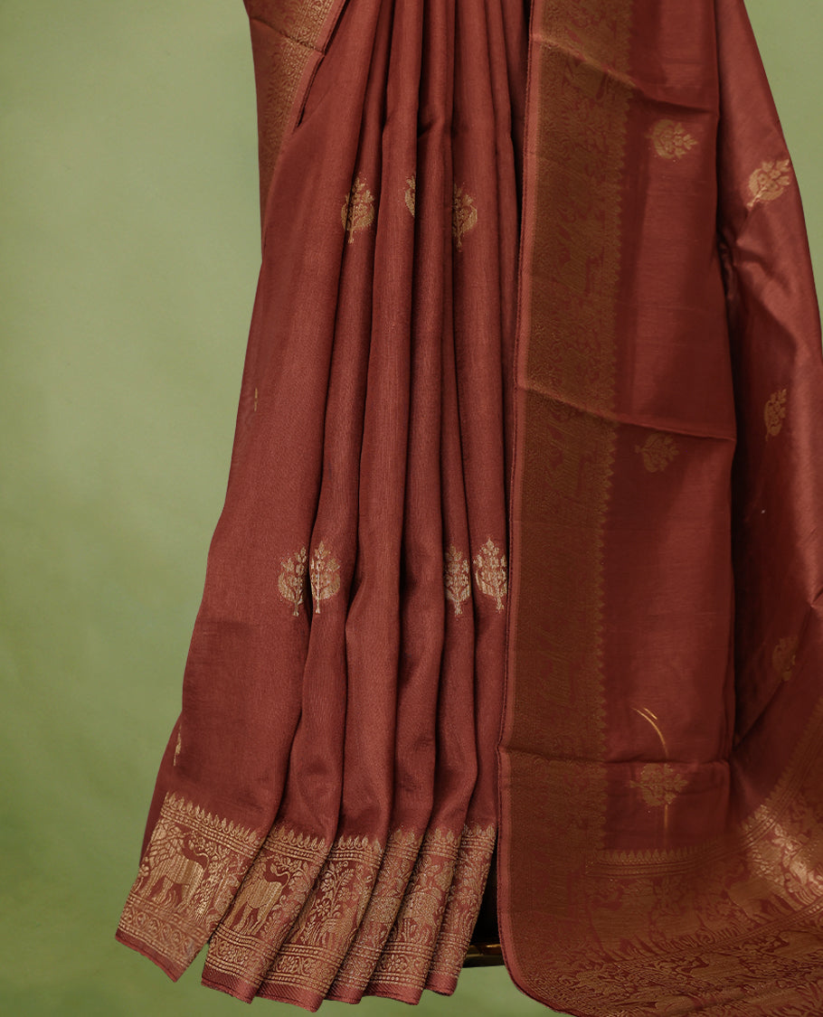 Rust Orange semi-Banaras tussar georgette saree adorned with antique zari butta motifs on the body, accentuated by a beautifully crafted jungle-themed border, and paired with a matching blouse.