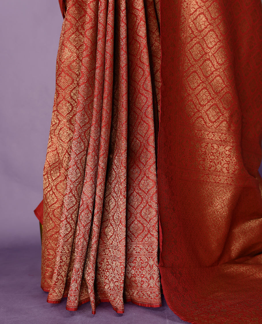 Maroon colour semi Banaras Katan saree featuring an antique Gold zari jacquard body, complemented by a self colour traditional border with a floral kodi design, paired with a matching blouse