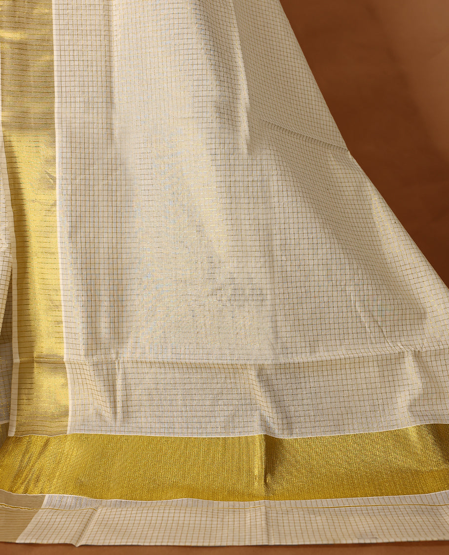 Elegant off white colour cotton Kerala saree featuring Tiny Checked body, gold zari traditional kasavu border offering a classic and graceful look, paired with a matching blouse.