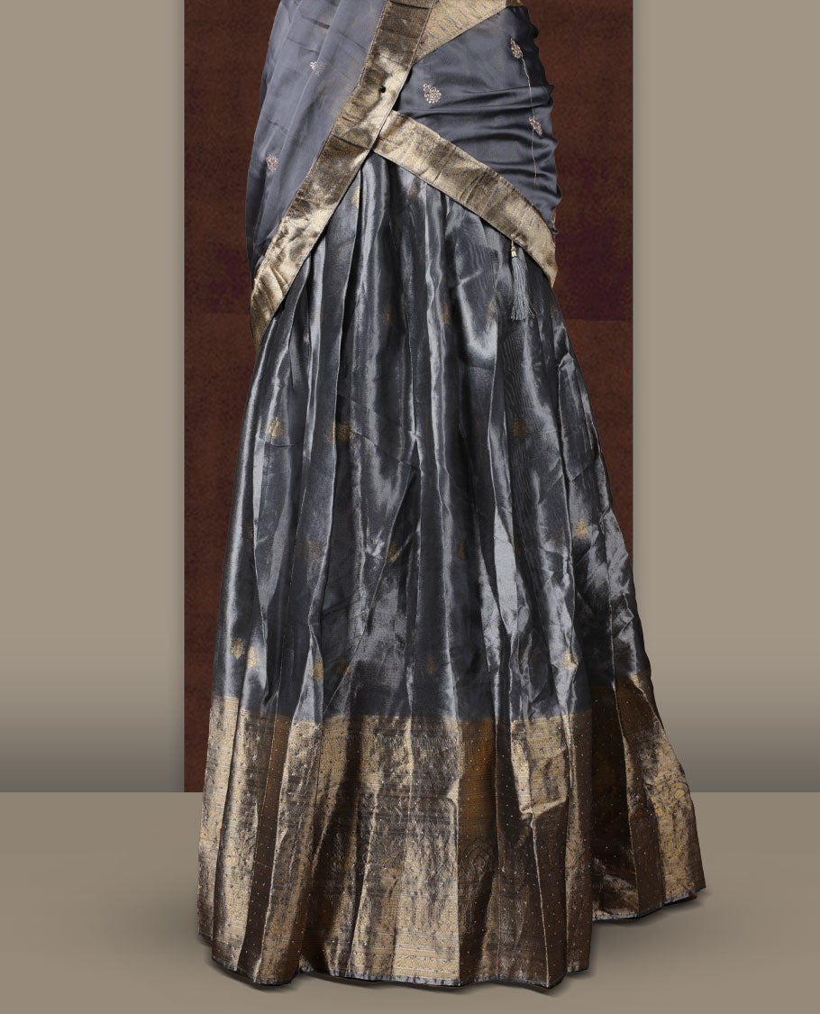 Gray colour Dhavani set featuring a Gray colour skirt with contrast Gold colour border with rich gold zari pattern, paired with a Matching dupatta detailed with Gold motifs.