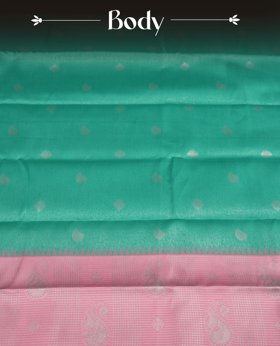Aqua green colour semi silk saree adorned with subtle silver zari motifs on the body, complemented by a pastel pink pallu intricately woven with rich floral patterns border and pallu, and paired with a matching blouse