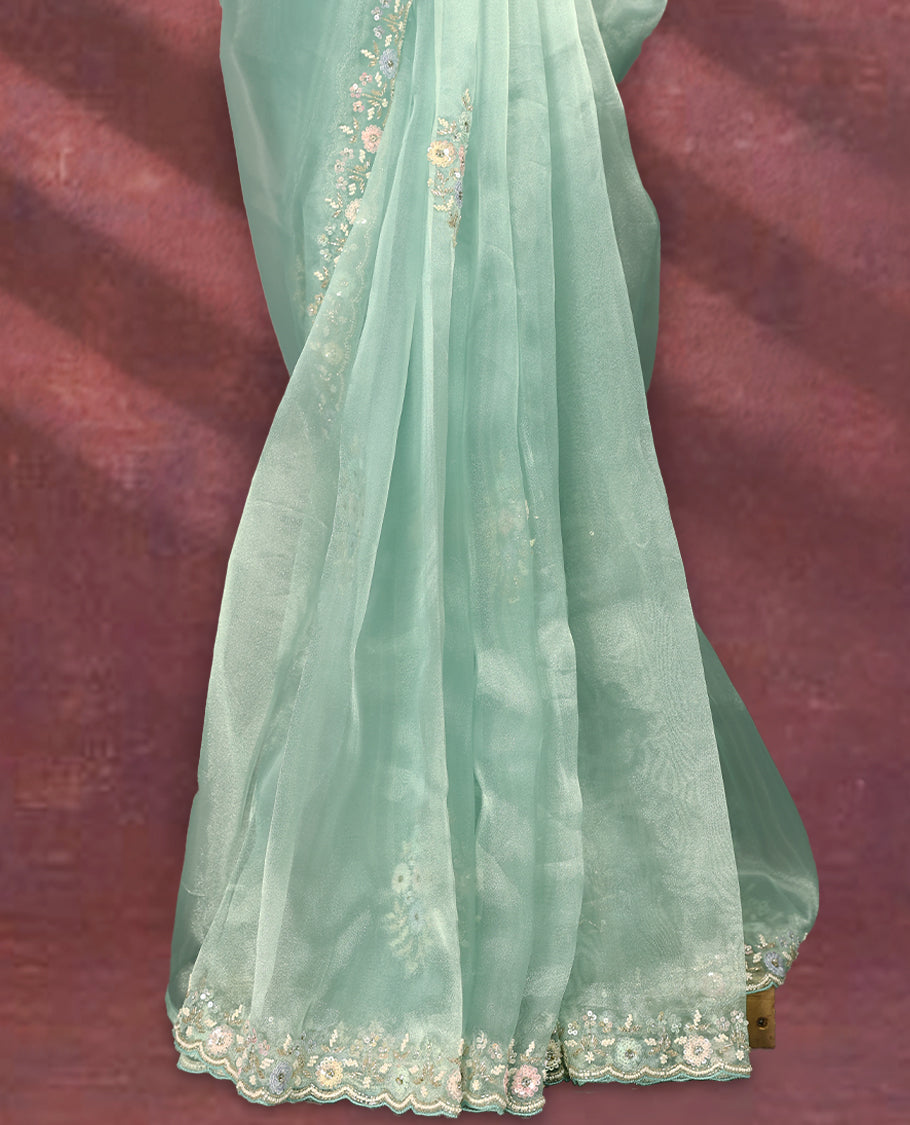 Aqua Green colour pure organza saree featuring all over floral sequin work, adorned with a matching intricately worked floral border, complemented by a richly embellished pallu and paired with a heavily worked matching blouse.
