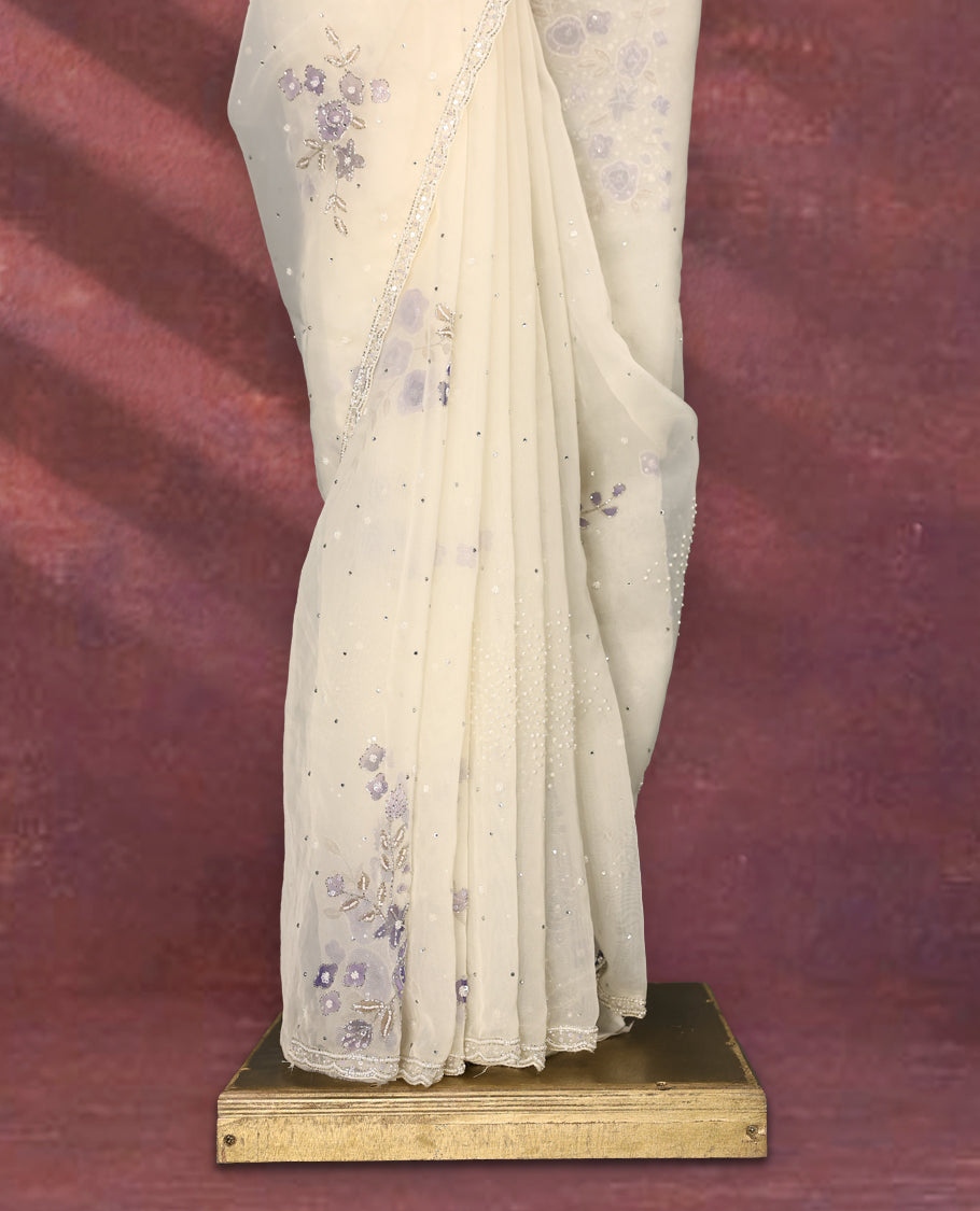 White colour pure organza saree featuring Lavender floral prints with intricate bead and sequin work across the body, adorned with a matching embellished border, complemented by a worked pallu and paired with a heavily worked matching blouse.