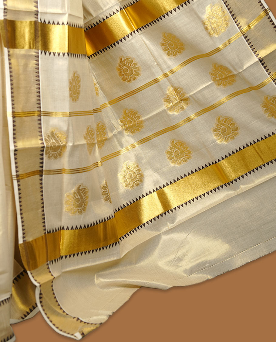 Light gold colour tissue Kerala saree featuring delicate gold zari buttas across the body, finished with a classic kasavu border highlighted by black triangle detailing, paired with a matching blouse.