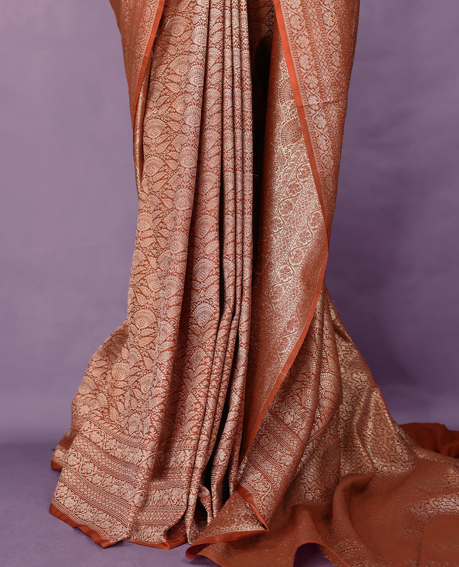 Light brown colour semi Banaras Katan saree featuring an antique silver zari jacquard body, complemented by a self colour traditional border with a floral kodi design, paired with a matching blouse