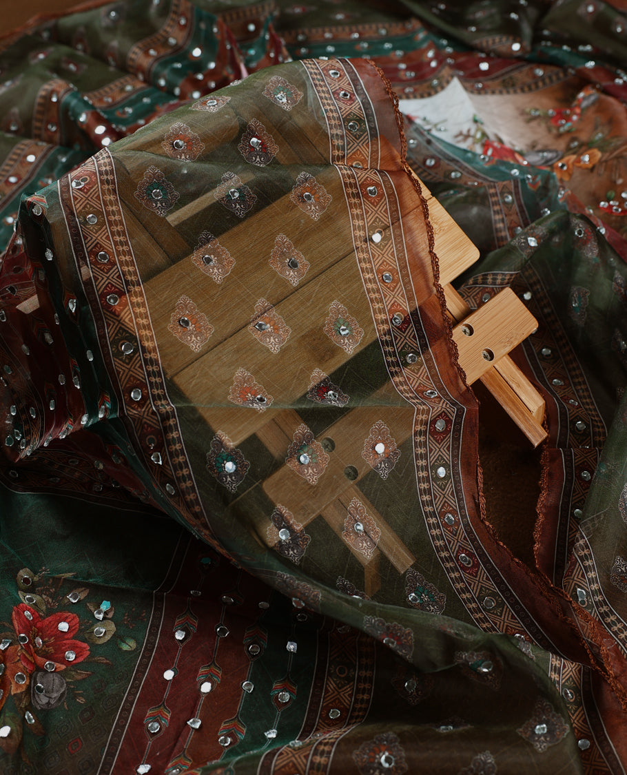 Elegant white churidhar material adorned with mirror work and subtle floral prints, enhanced by a rich green brown printed dupatta with sequin highlights, paired with a plain white bottom for a classy festive look.