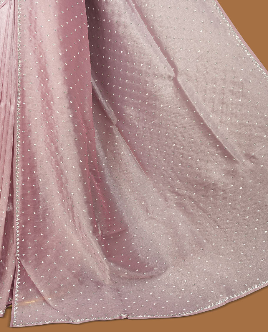 Pink colour net shimmer fancy saree adorned with scattered white stone buttas all over the body, paired with a delicate stone worked border and matching blouse.