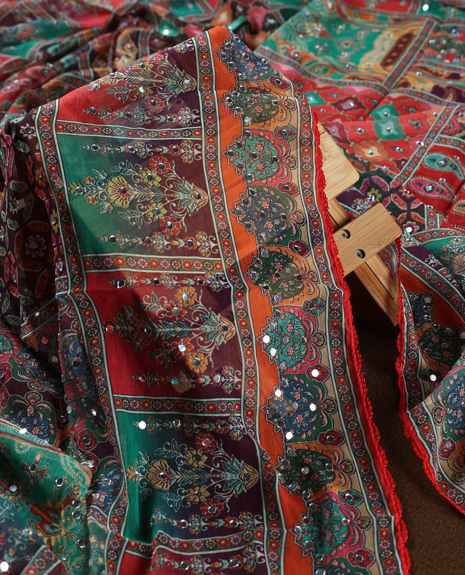 Red colour churidar material with rich floral and striped patterns enhanced by delicate mirror work, paired with a plain matching bottom and ornate dupatta.