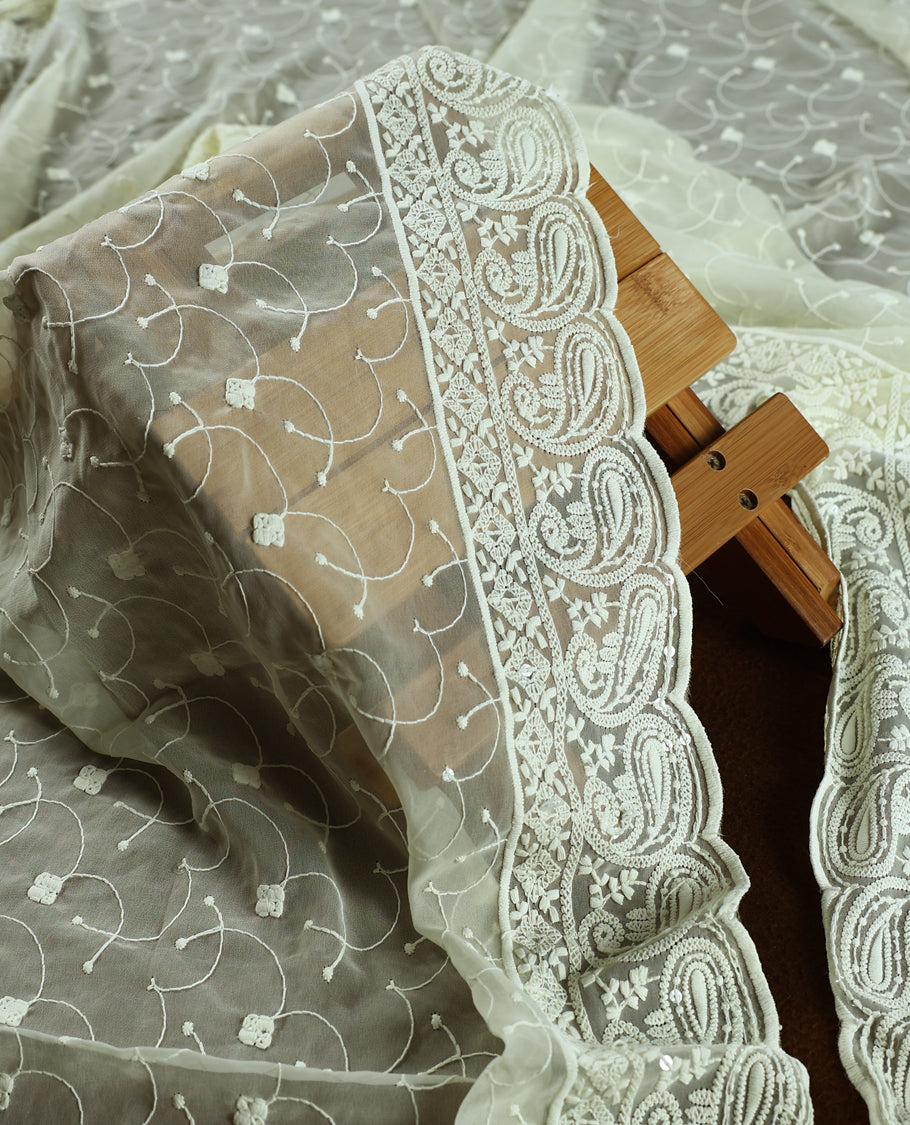 Cream churidhar material with embroidered green colour neck work, white threadwork on the body, and multicolor floral motifs in pink, green & yellow & Comes with matching plain bottom and embroidered dupatta.