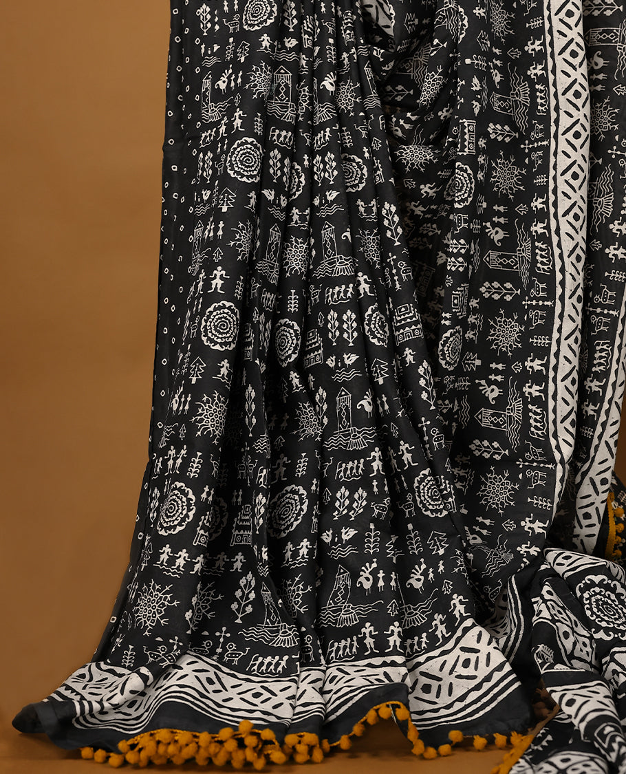 Black cotton saree features intricate white handblock prints, a beautifully detailed border with mustard piping and Self Coloured Blouse