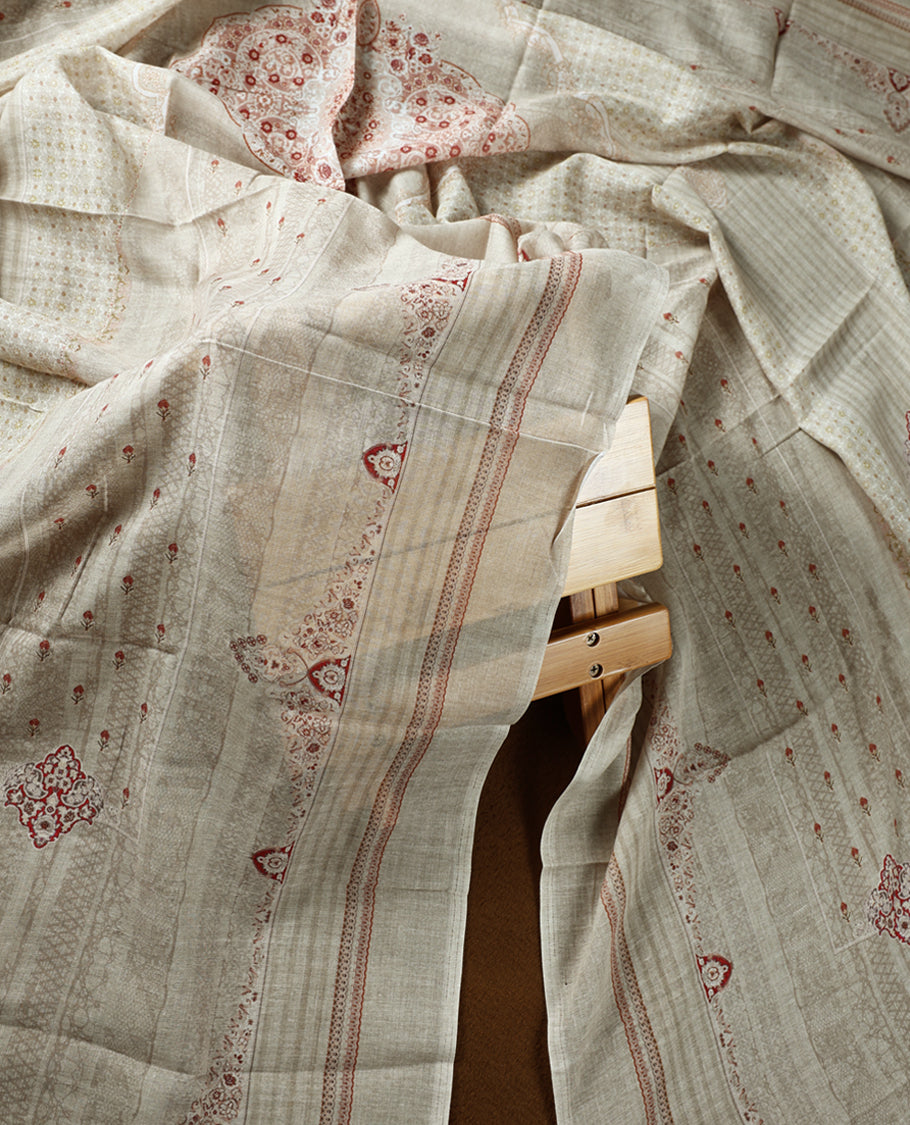 Beige colour churidhar material adorned with subtle printed motifs and sequin highlights, paired with a plain matching bottom and a printed dupatta.