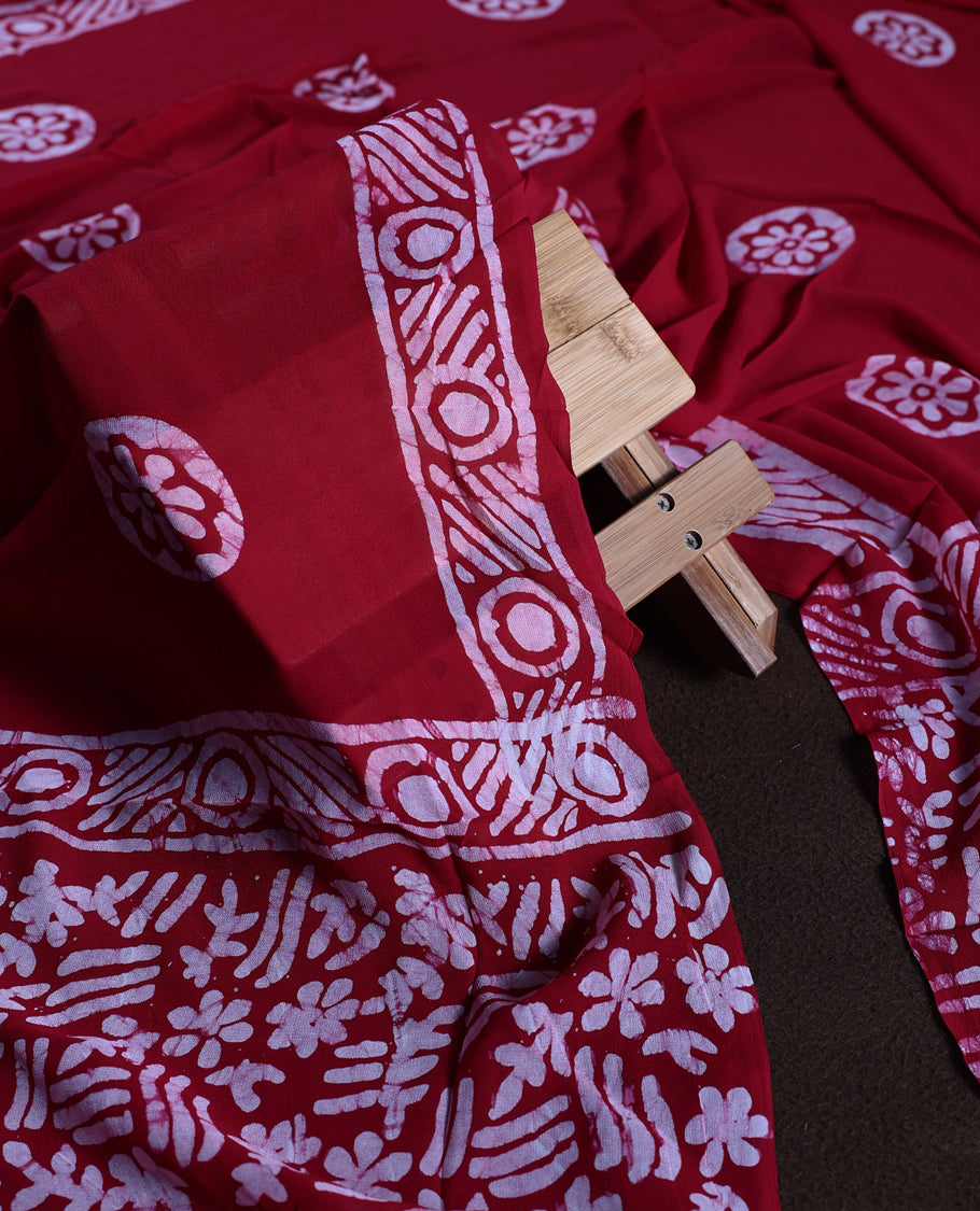 Maroon colour churidhar material adorned with gold and copper toned floral patterns and bold block designs, paired with a plain matching bottom and stylish dupatta, perfect for festive evenings and traditional gatherings.