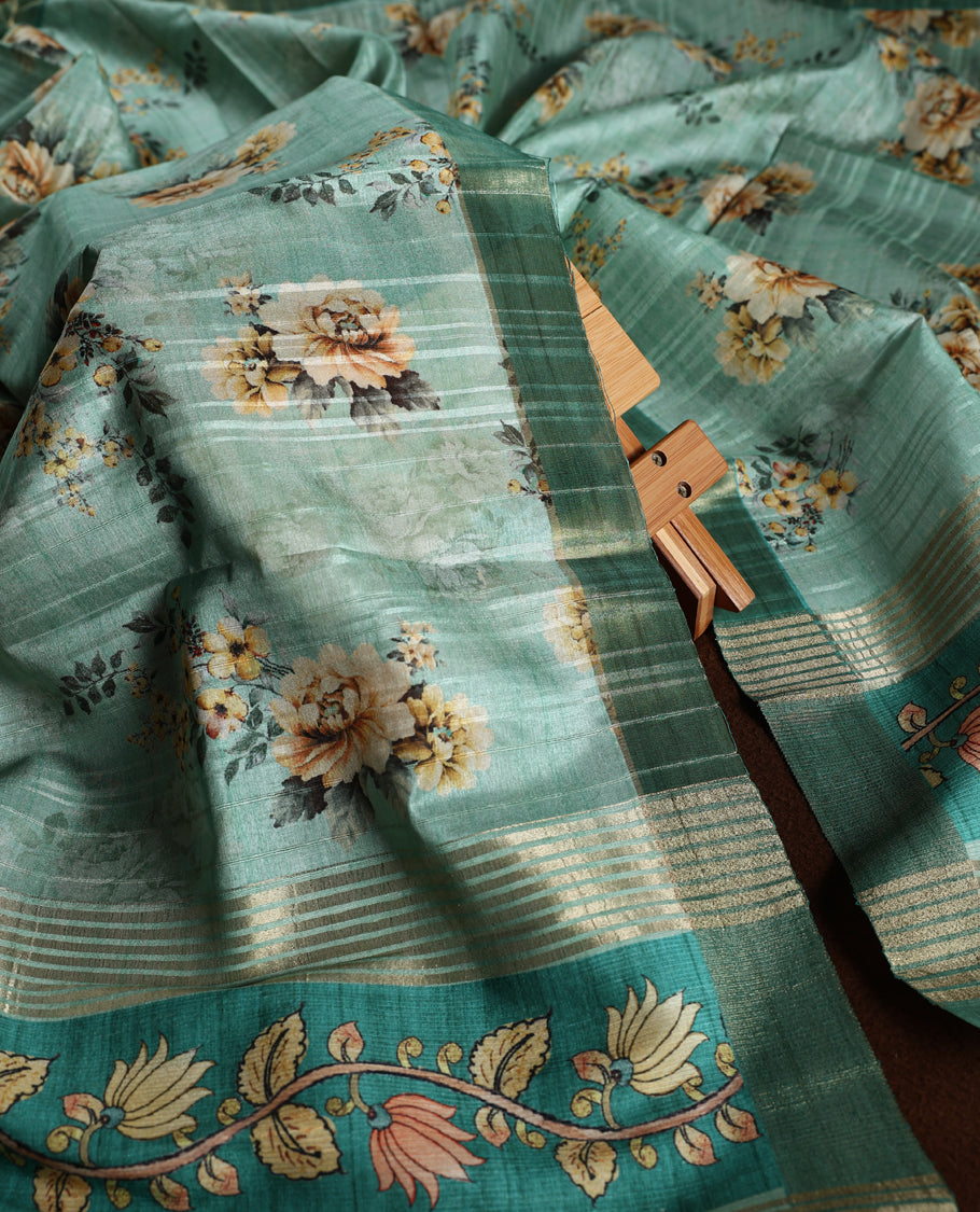 Light peacock green colour churidhar material adorned with floral embroidery and sewn glass beads on the yoke, paired with a plain green bottom and a beige dupatta featuring floral prints.
